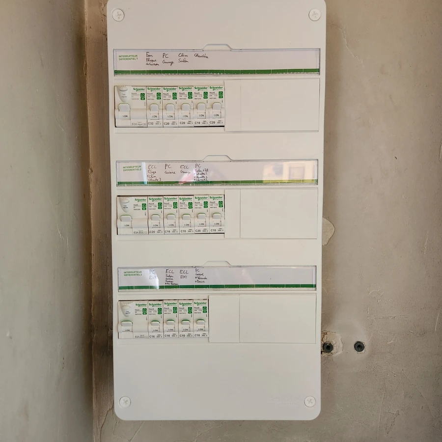 Tableau électrique mural avec trois rangées de disjoncteurs Schneider Electric et étiquetage des circuits